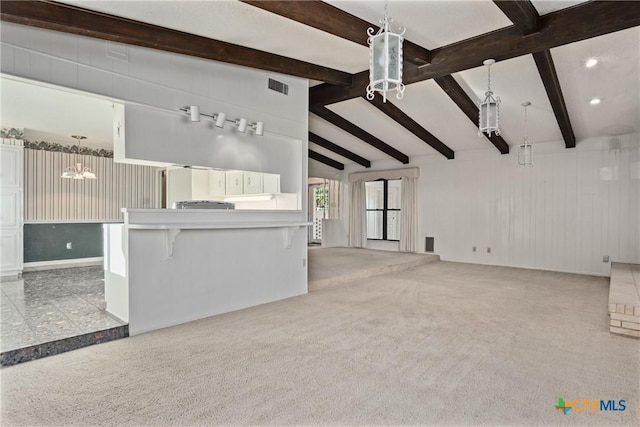 unfurnished living room with light carpet and lofted ceiling with beams