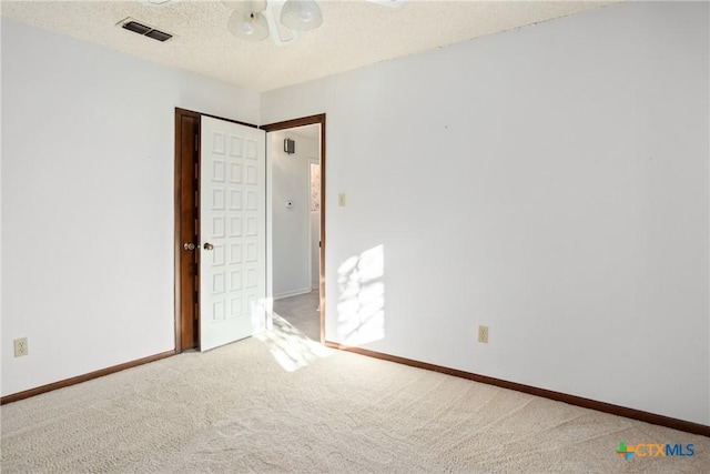 carpeted spare room with a textured ceiling