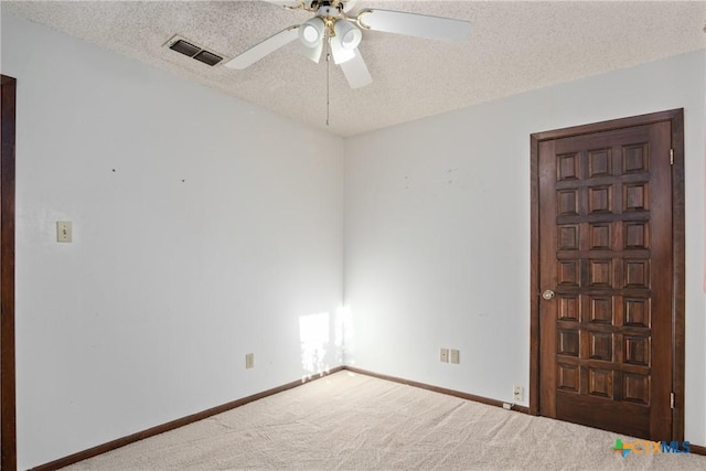 carpeted empty room featuring ceiling fan and a textured ceiling