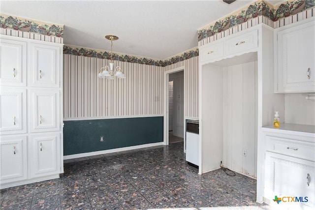 unfurnished dining area featuring a chandelier