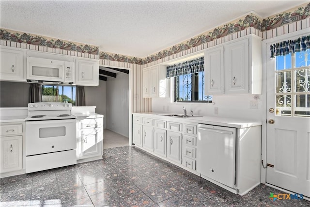 kitchen with white cabinets, sink, white appliances, and a textured ceiling