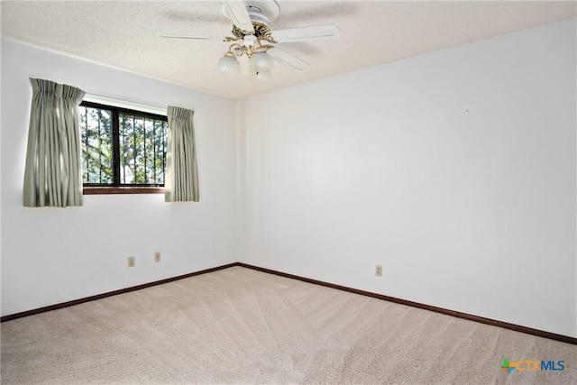 spare room featuring a textured ceiling, ceiling fan, and light colored carpet