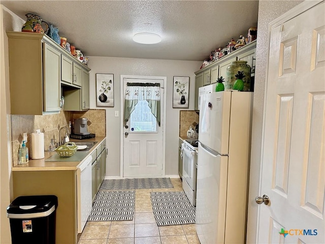 kitchen with white appliances, tasteful backsplash, light countertops, a sink, and light tile patterned flooring