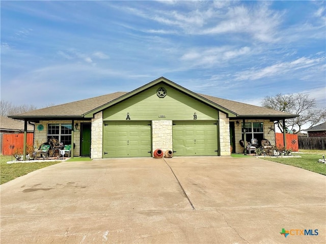 view of front of house featuring concrete driveway, a shingled roof, an attached garage, and fence