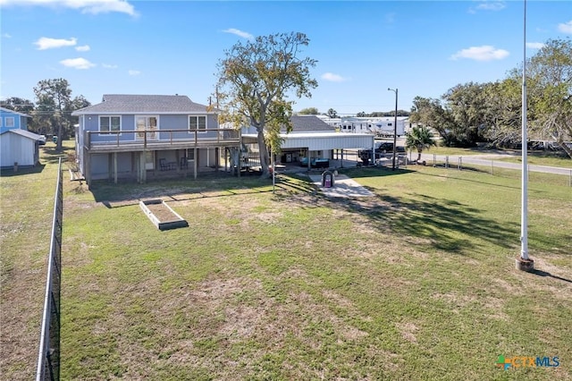 exterior space with a lawn, a deck, and fence