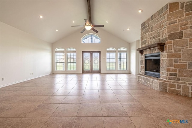 45 Blue Heron Dr, Port Lavaca, TX 77979 - unfurnished living room featuring beam ceiling, light tile patterned flooring, a stone fireplace, ceiling fan, and high vaulted ceiling