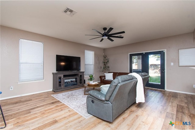 living room with light wood-type flooring and ceiling fan