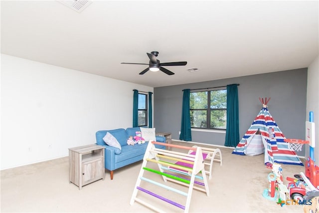 playroom with ceiling fan and light colored carpet