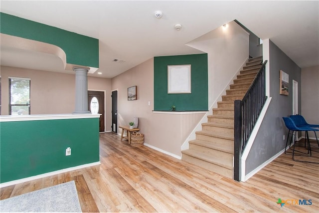 foyer featuring light hardwood / wood-style floors and decorative columns