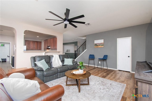 living room featuring light wood-type flooring and ceiling fan