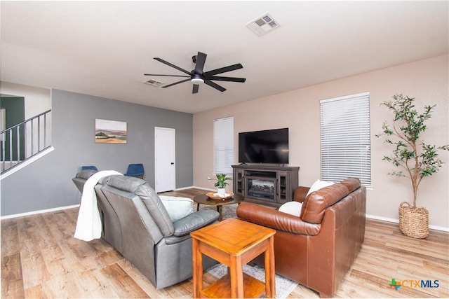 living room featuring light hardwood / wood-style floors and ceiling fan