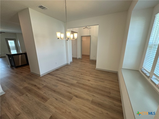 unfurnished dining area with dark hardwood / wood-style flooring and a chandelier