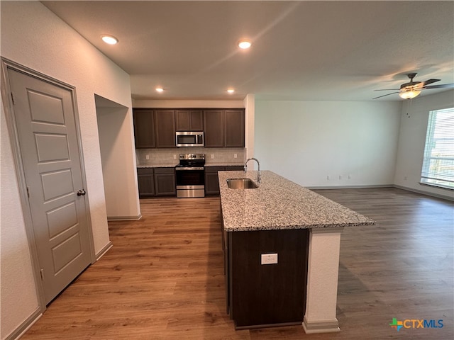 kitchen featuring dark brown cabinetry, hardwood / wood-style flooring, appliances with stainless steel finishes, and sink