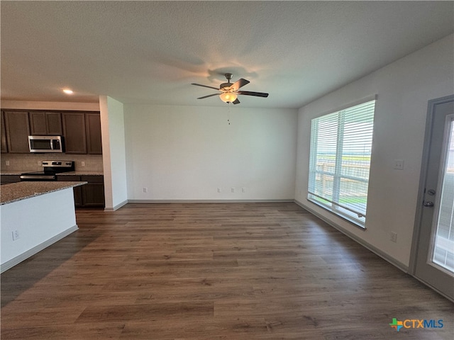 unfurnished living room with a textured ceiling, dark hardwood / wood-style floors, and ceiling fan