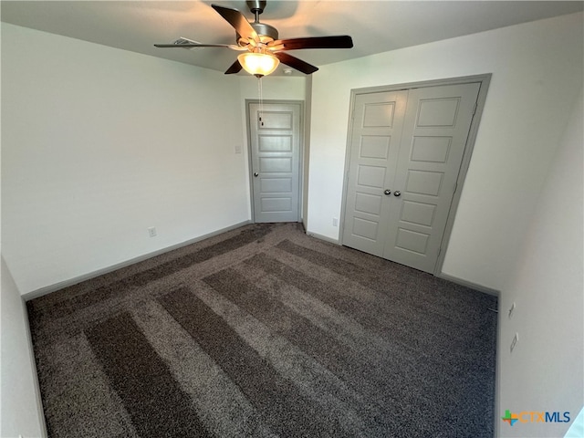 unfurnished bedroom featuring a closet, carpet flooring, and ceiling fan