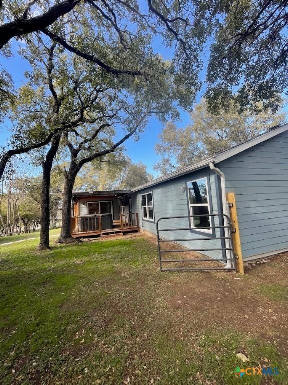 back of house featuring a lawn and a porch