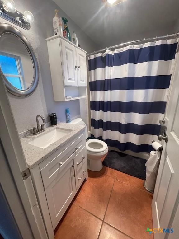 bathroom with tile patterned flooring, vanity, toilet, and a shower with shower curtain