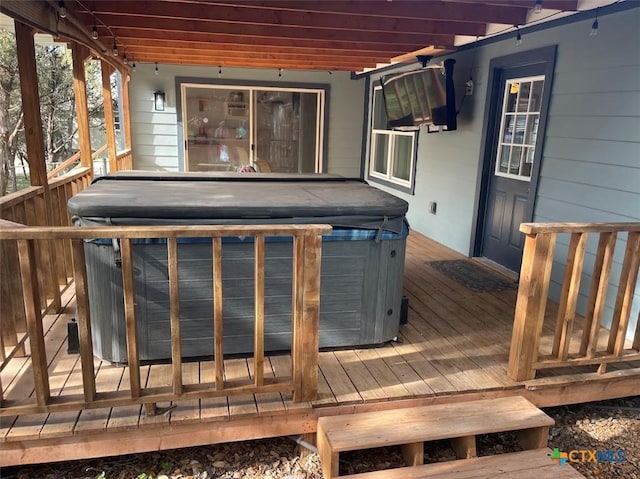 wooden deck with a hot tub and a pergola