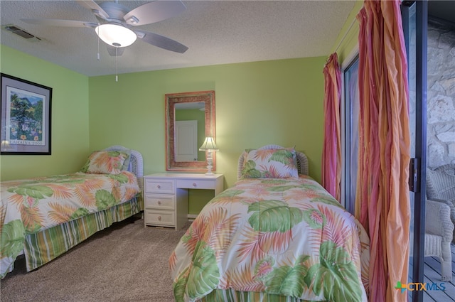 carpeted bedroom featuring ceiling fan and a textured ceiling