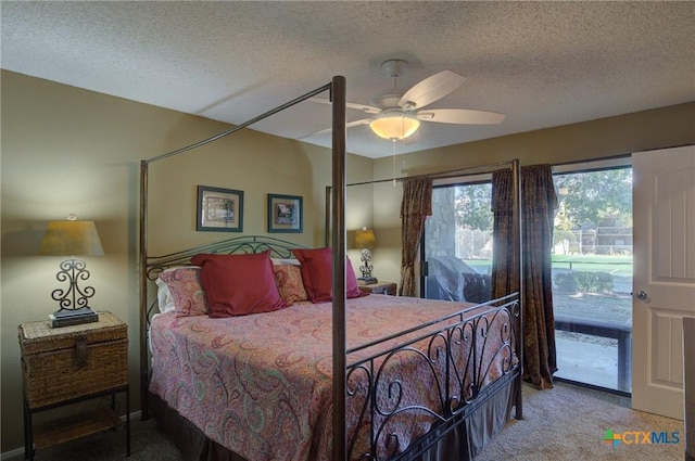 carpeted bedroom with ceiling fan and a textured ceiling