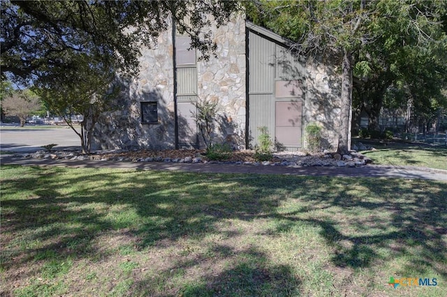 view of side of home with a yard