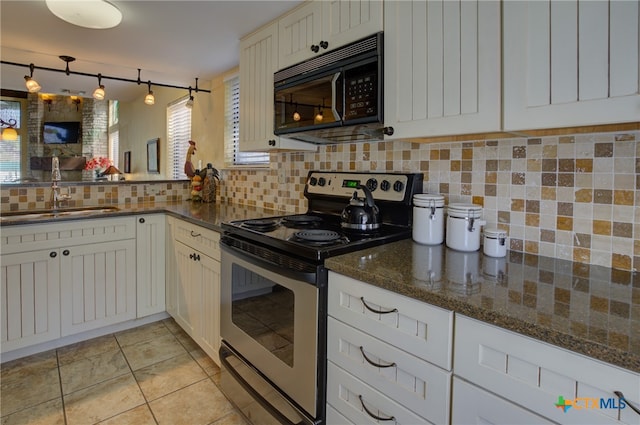 kitchen featuring electric stove, light tile patterned floors, sink, and dark stone counters