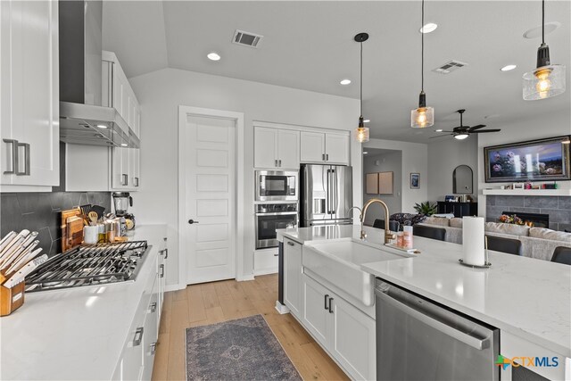 kitchen with white cabinetry, hanging light fixtures, ceiling fan, and stainless steel appliances