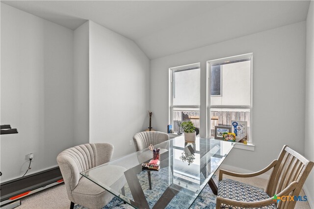 dining space with carpet floors and lofted ceiling