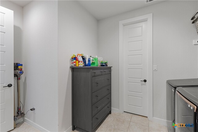 washroom with light tile patterned floors and washing machine and clothes dryer