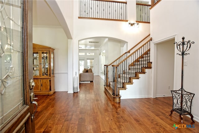 1108 Celtic Cv, Round Rock, TX 78681 - foyer entrance with a towering ceiling, arched walkways, wood-type flooring, and stairs