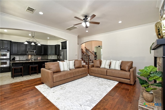 1108 Celtic Cv, Round Rock, TX 78681 - living room with arched walkways, ceiling fan, light wood finished floors, ornamental molding, and recessed lighting
