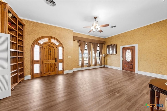 foyer entrance featuring visible vents, baseboards, wood finished floors, and wallpapered walls