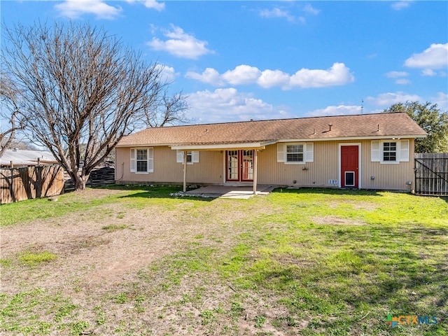 rear view of property featuring a patio area, a fenced backyard, and a yard