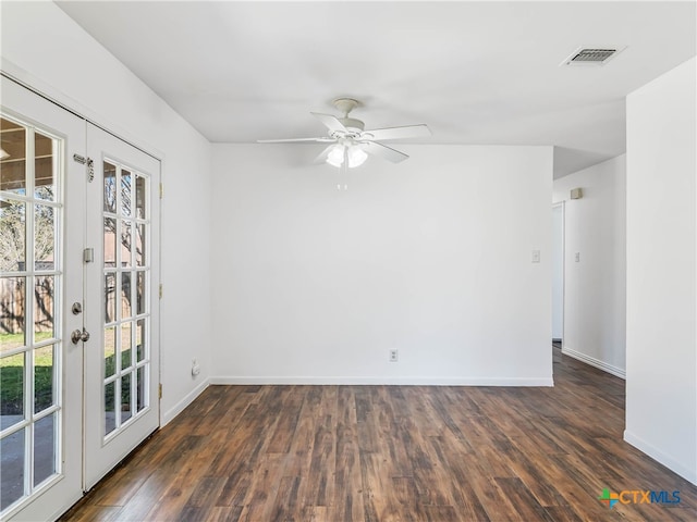 spare room featuring baseboards, visible vents, dark wood-type flooring, and french doors