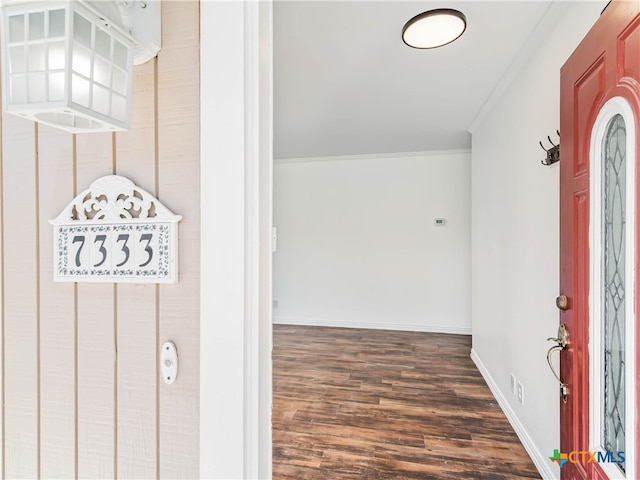 interior space featuring ornamental molding, dark wood finished floors, and baseboards