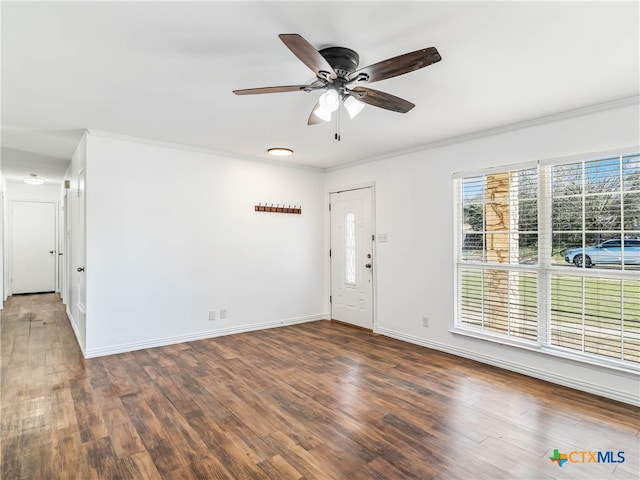 foyer entrance with dark wood-type flooring, ornamental molding, baseboards, and ceiling fan