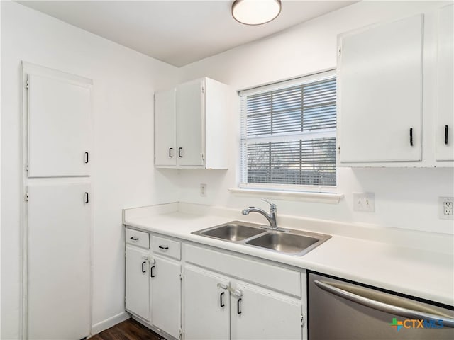 kitchen with dishwasher, light countertops, a sink, and white cabinetry