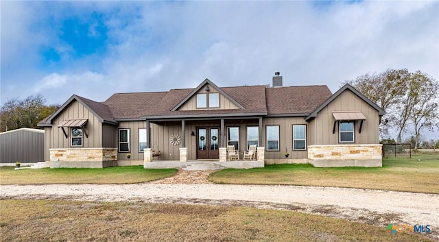 view of front facade featuring french doors and a front lawn