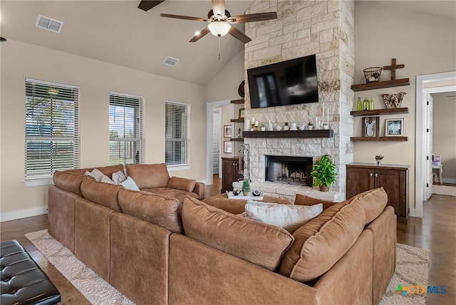 living room featuring high vaulted ceiling, a stone fireplace, dark hardwood / wood-style floors, and ceiling fan