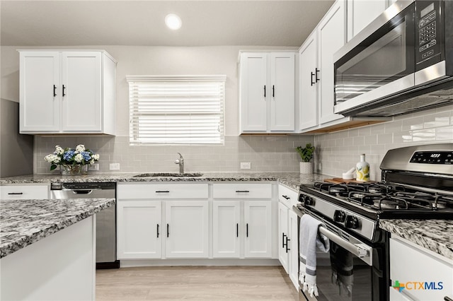 419 Agave Flats Dr, New Braunfels, TX 78130 - kitchen with stainless steel appliances, white cabinetry, backsplash, and recessed lighting