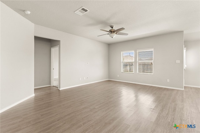419 Agave Flats Dr, New Braunfels, TX 78130 - empty room featuring a ceiling fan, a smoke detector, wood finished floors, and a textured ceiling