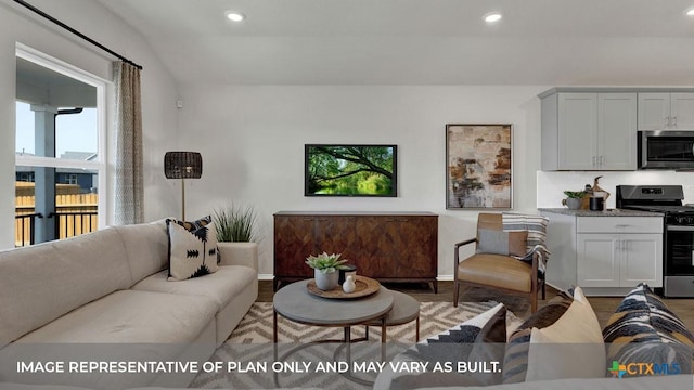 living area with baseboards, wood finished floors, and recessed lighting