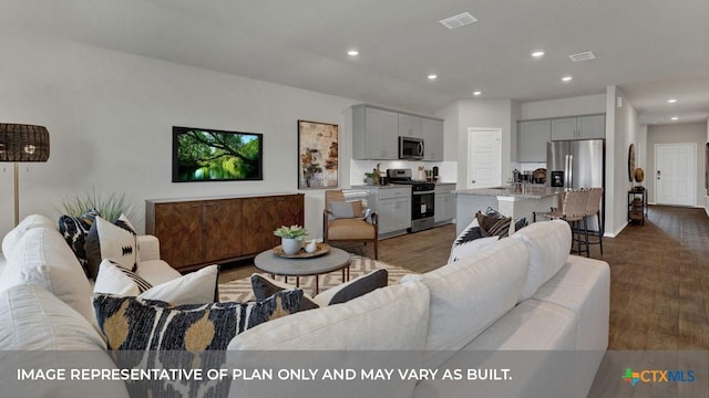 living area with wood finished floors, visible vents, and recessed lighting