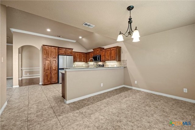 1722 Shadow Canyon Dr, Temple, TX 76502 - kitchen with stainless steel appliances, lofted ceiling, a peninsula, tasteful backsplash, and arched walkways