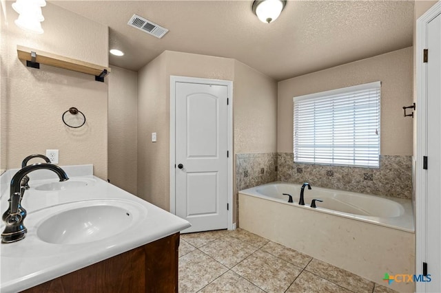 1722 Shadow Canyon Dr, Temple, TX 76502 - full bath featuring a bath, tile patterned floors, double vanity, a textured ceiling, and a textured wall