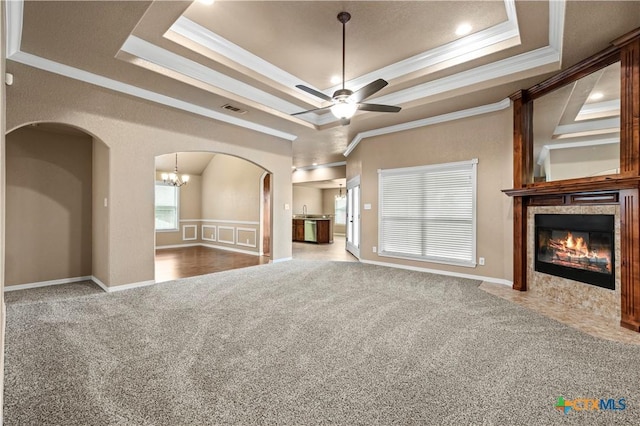 1722 Shadow Canyon Dr, Temple, TX 76502 - unfurnished living room with ornamental molding, arched walkways, carpet, a tray ceiling, and a tile fireplace