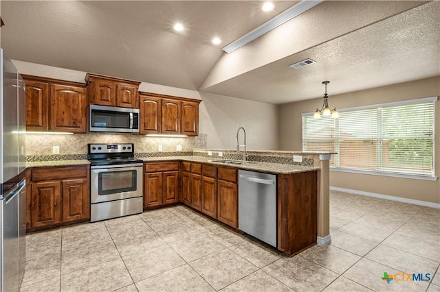 1722 Shadow Canyon Dr, Temple, TX 76502 - kitchen featuring appliances with stainless steel finishes, a peninsula, backsplash, a chandelier, and light stone countertops