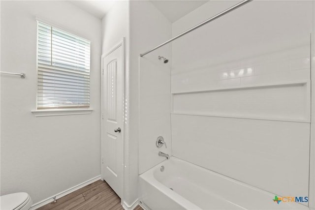 bathroom featuring toilet, hardwood / wood-style floors, and shower / bathing tub combination