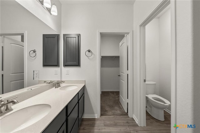 bathroom with hardwood / wood-style flooring, vanity, and toilet