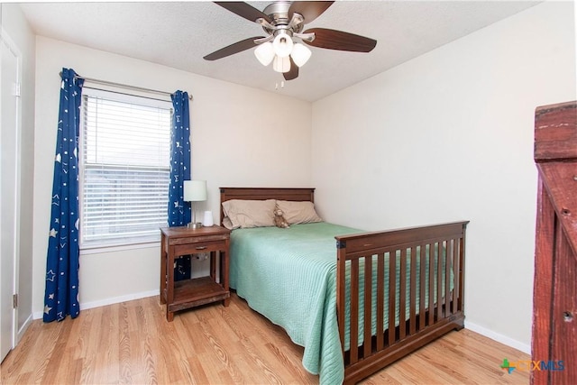 bedroom with ceiling fan, baseboards, and wood finished floors